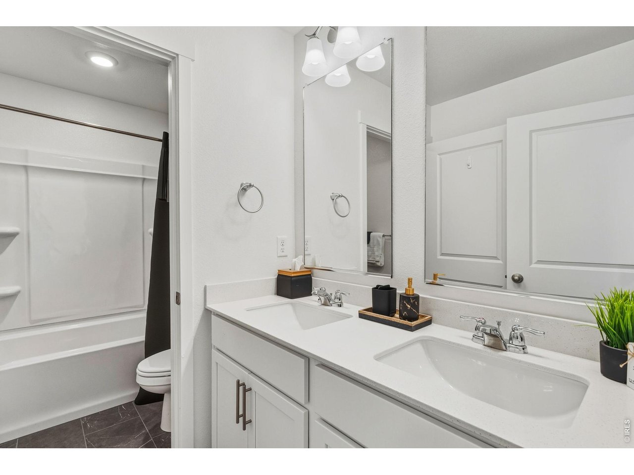 438 Bluebird Road Johnstown, CO 80534 - Photo 27 of 33 Secondary bath with double sinks, tile flooring and tub/shower combo.