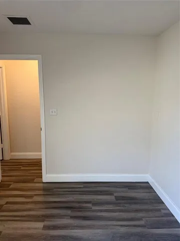 a view of a small space with wooden floor and a window