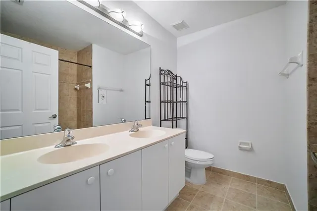 a bathroom with a sink a toilet and a large mirror