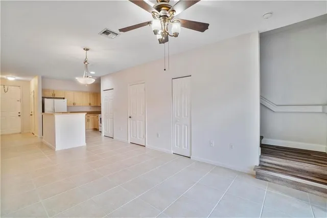 a view of a kitchen with an empty space and a ceiling fan