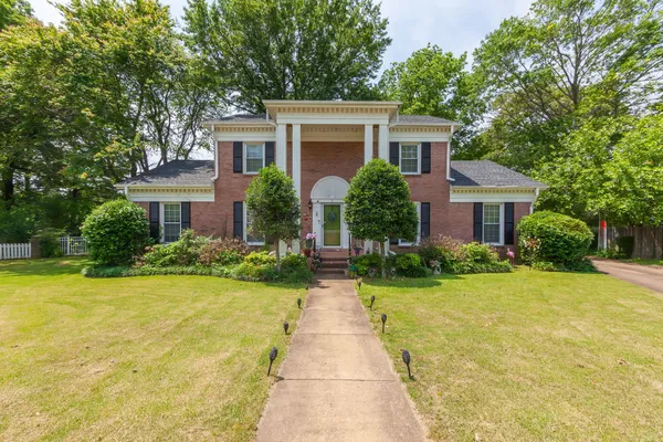 a front view of house with yard and green space
