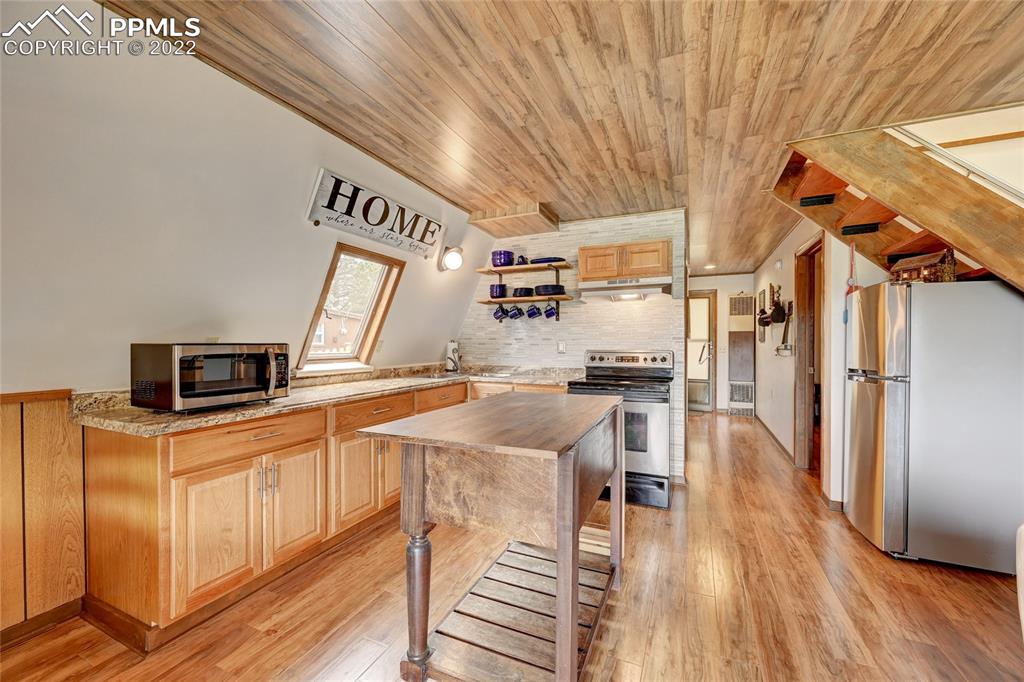 67 Pine Street Rye, CO 81069 - Photo 24 of 42 a open kitchen with stainless steel appliances granite countertop a refrigerator a sink and wooden floors