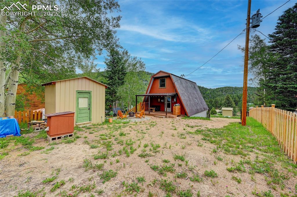 67 Pine Street Rye, CO 81069 - Photo 5 of 42 a backyard of a house with wooden fence and a toy car