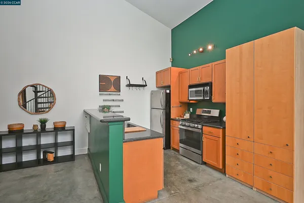 a kitchen with stainless steel appliances granite countertop a refrigerator and a stove top oven