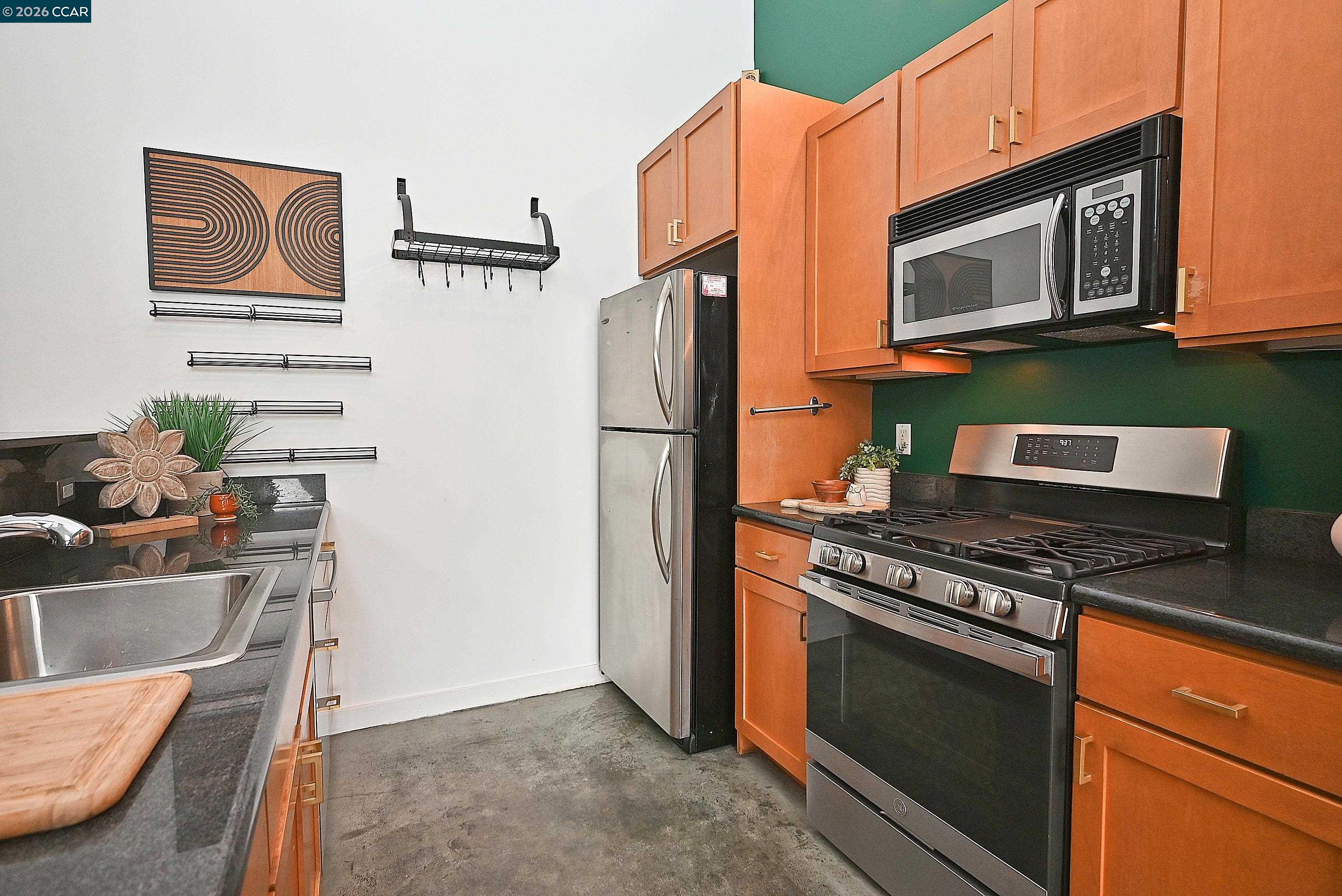 675 8th Street, Unit 15 Oakland, CA 94607 - Photo 18 of 38 a kitchen with stainless steel appliances granite countertop a refrigerator stove and microwave