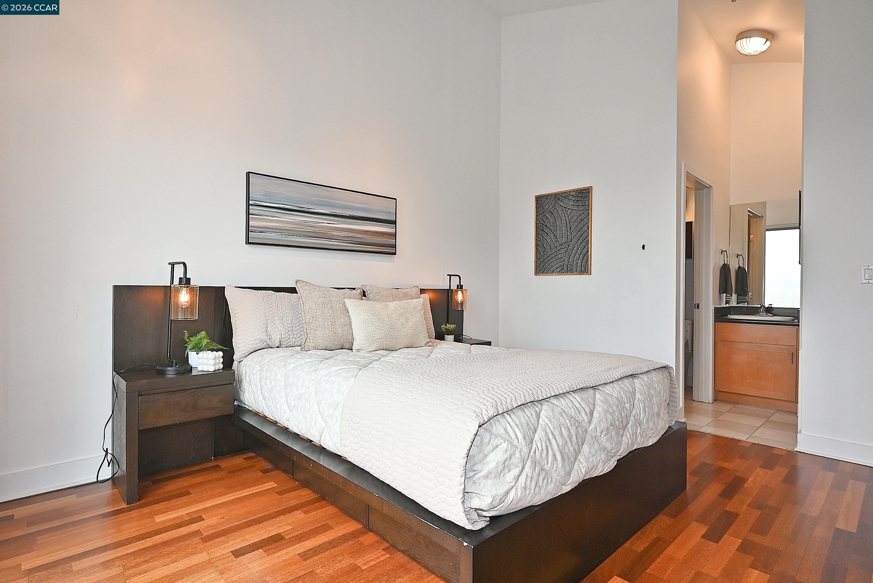 675 8th Street, Unit 15 Oakland, CA 94607 - Photo 31 of 38 a bedroom with a bed and wooden floor