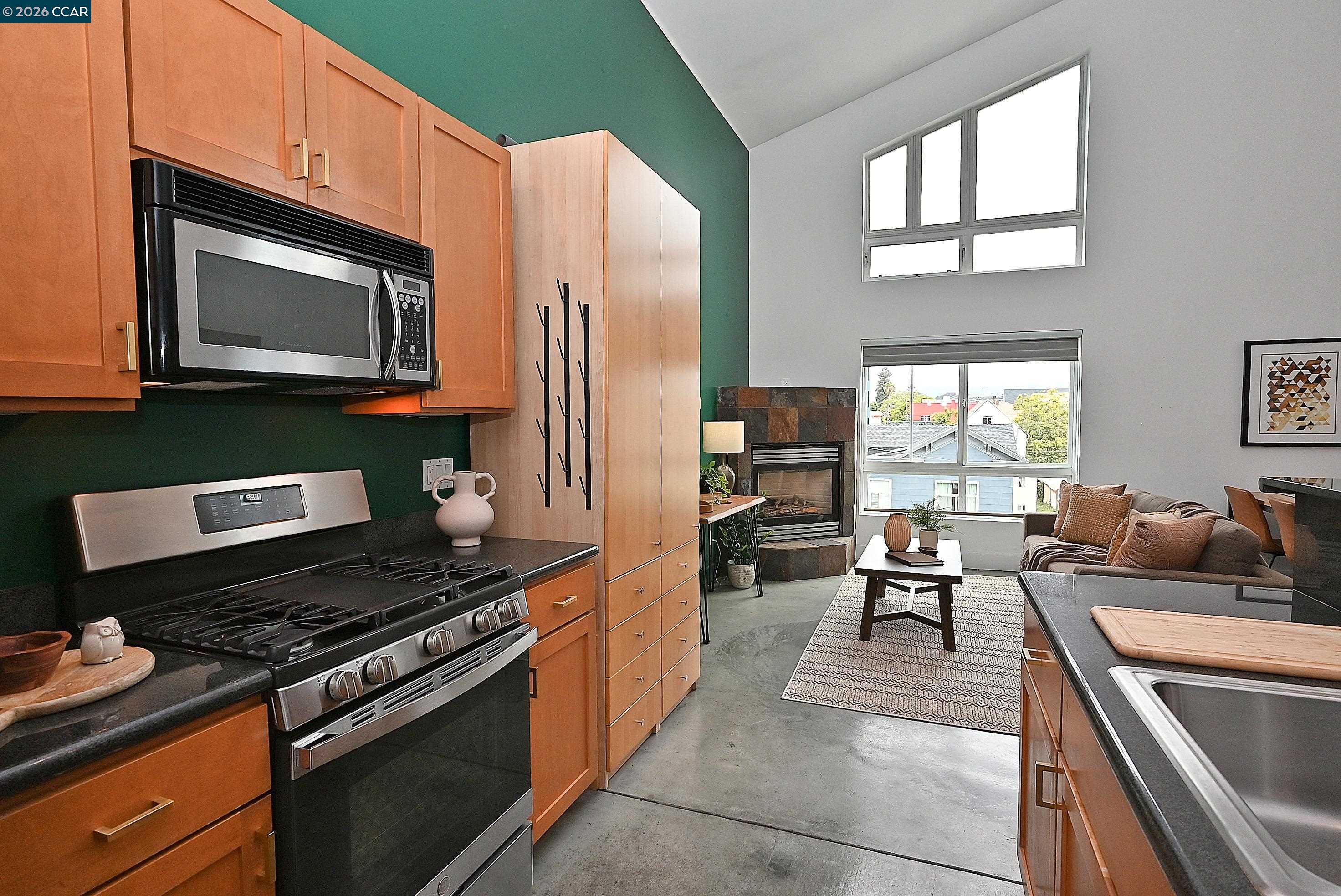 675 8th Street, Unit 15 Oakland, CA 94607 - Photo 6 of 38 a kitchen with stainless steel appliances granite countertop a stove top oven a sink dishwasher a dining table and chairs with wooden floor