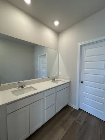 a bathroom with a double vanity sink and mirror
