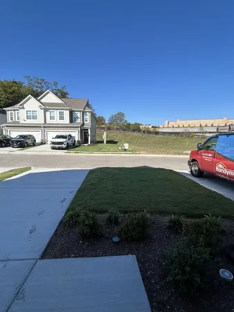a front view of a house with a garden and lake view