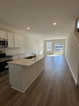 a kitchen with a sink and wooden floor
