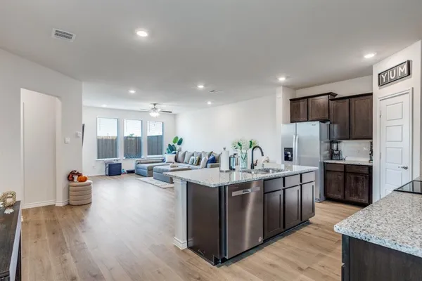a kitchen with granite countertop stainless steel appliances a sink stove and refrigerator