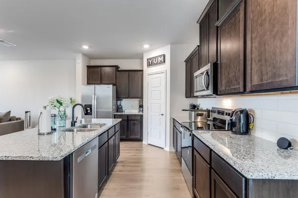 a kitchen with stainless steel appliances granite countertop a stove refrigerator sink and cabinets