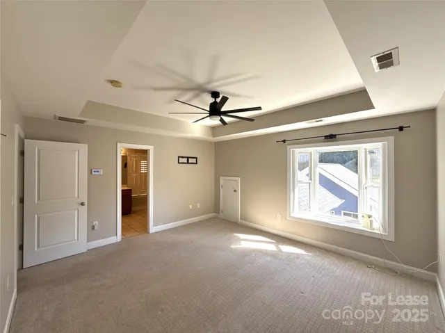 an empty room with windows and fan