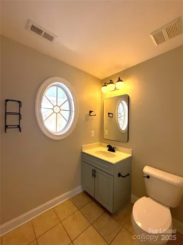 a bathroom with a toilet sink vanity and mirror