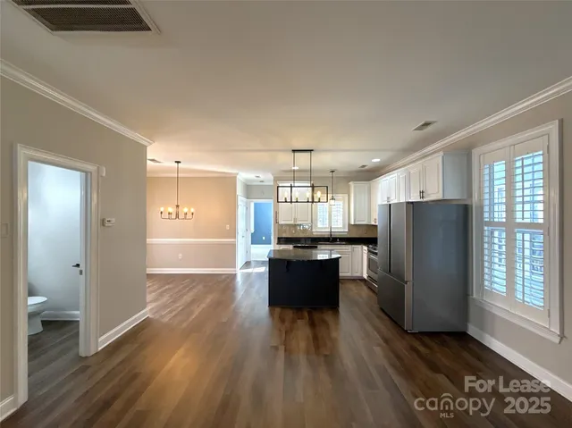a kitchen with a refrigerator and a wooden cabinets