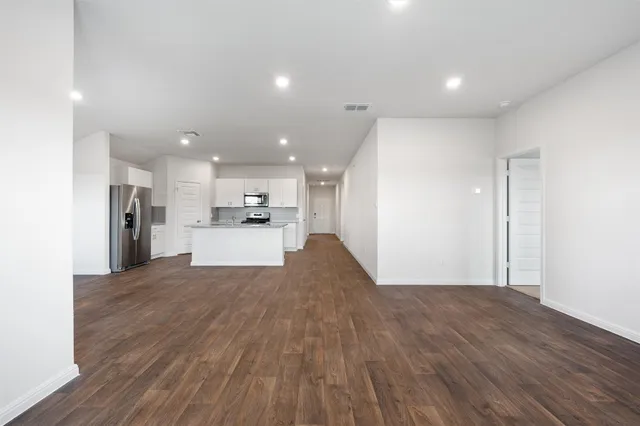a view of a kitchen with a sink and wooden floor