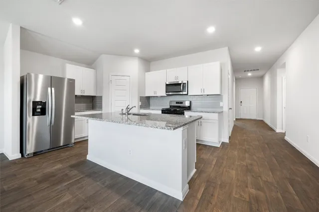a kitchen with stainless steel appliances a refrigerator and a stove top oven