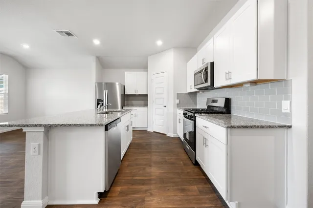 a kitchen with stainless steel appliances a sink and a refrigerator