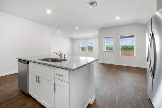 a view of a kitchen with a sink and wooden floor