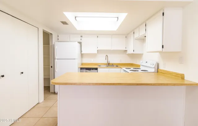 a kitchen with a refrigerator sink and cabinets