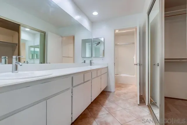 a spacious bathroom with a double vanity sink and mirror