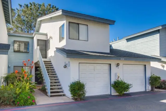 a front view of a house with plants