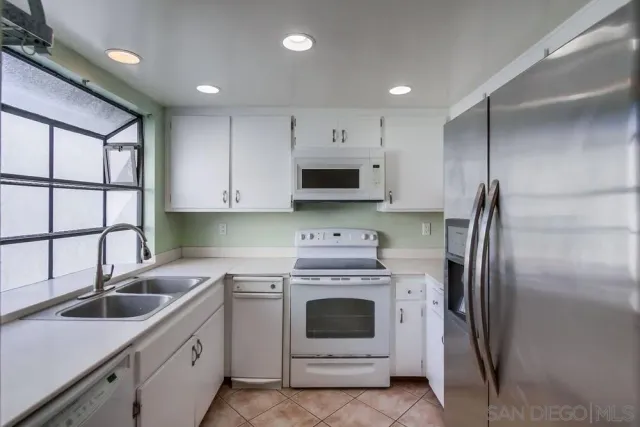 a kitchen with cabinets stainless steel appliances and a sink