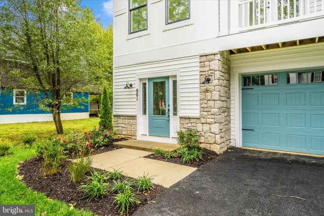 a large white kitchen with stainless steel appliances a stove a sink a refrigerator and white cabinets with wooden floor