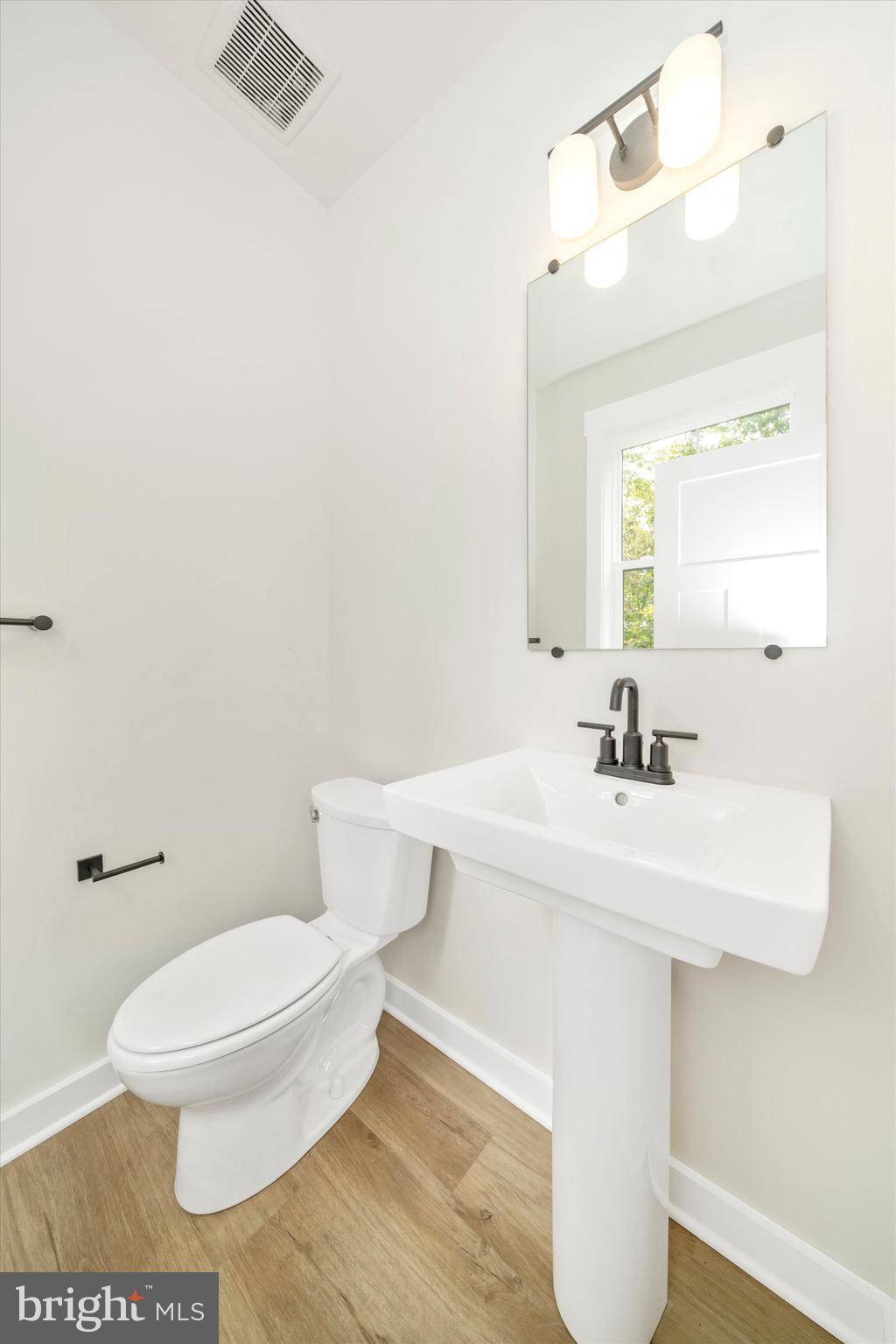 203 Riverside Drive Chester, MD 21619 - Photo 36 of 68 a bathroom with a sink a toilet and mirror