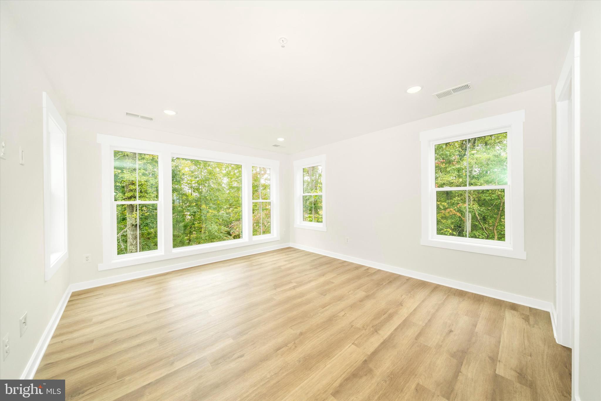 203 Riverside Drive Chester, MD 21619 - Photo 52 of 68 an empty room with wooden floor and windows