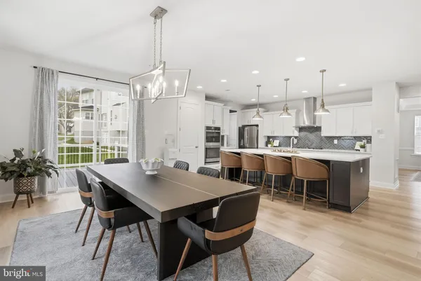 a large kitchen with kitchen island a island a sink a stove and a wooden floors