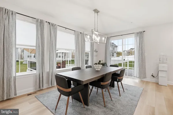 a kitchen with a dining table chairs and white cabinets