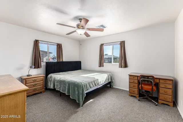 a bedroom with a bed and a ceiling fan