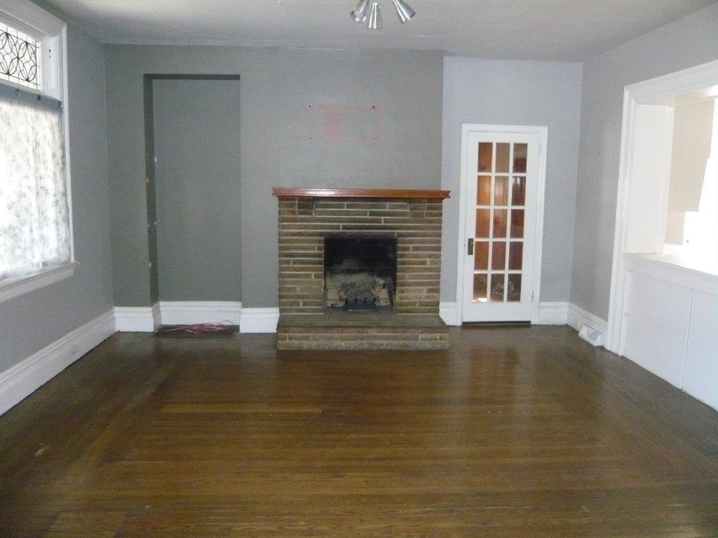 632 Blackburn Road Sewickley, PA 15143 - Photo 5 of 16 Bright living room with picture window and leaded glass above. Warm wood floors. Door to paneled den.