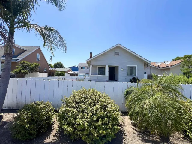 a front view of a house with a yard and plants