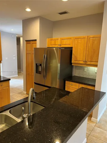 a view of a kitchen with refrigerator and microwave