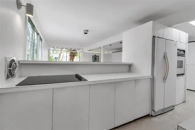 a kitchen with a sink a refrigerator and cabinets