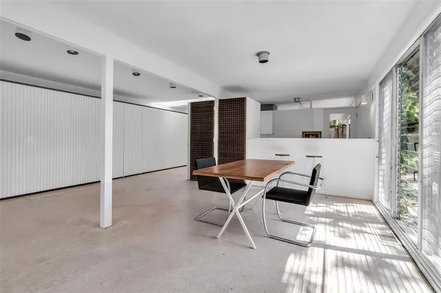 a living room with a window and chairs