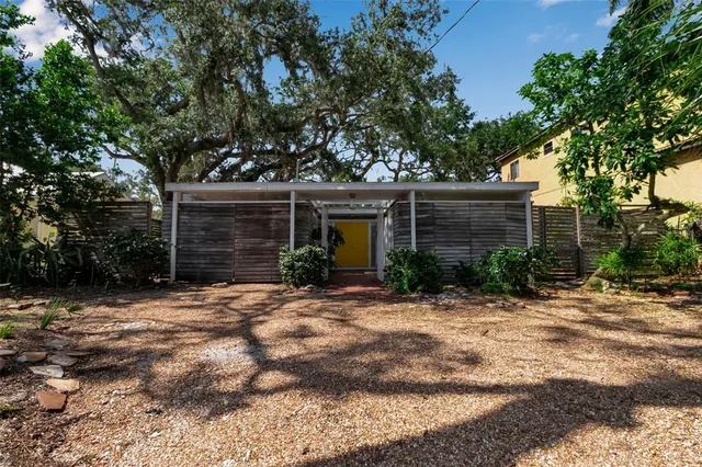 a front view of a house with a tree