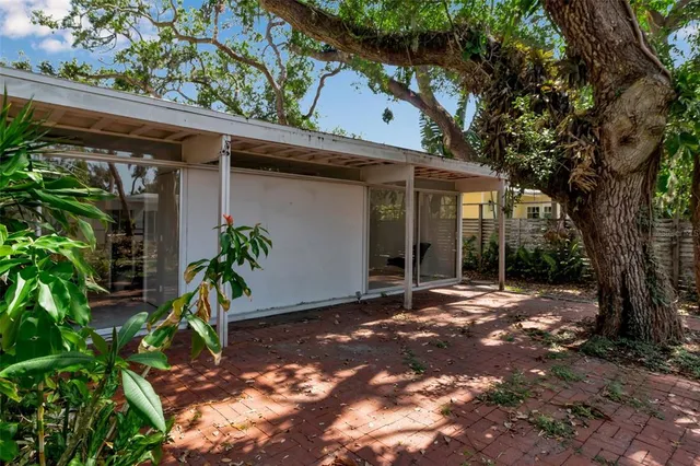 a view of a wooden house with a large tree