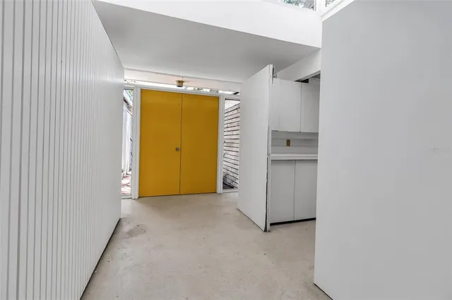 a view of an empty room with closet and wooden door