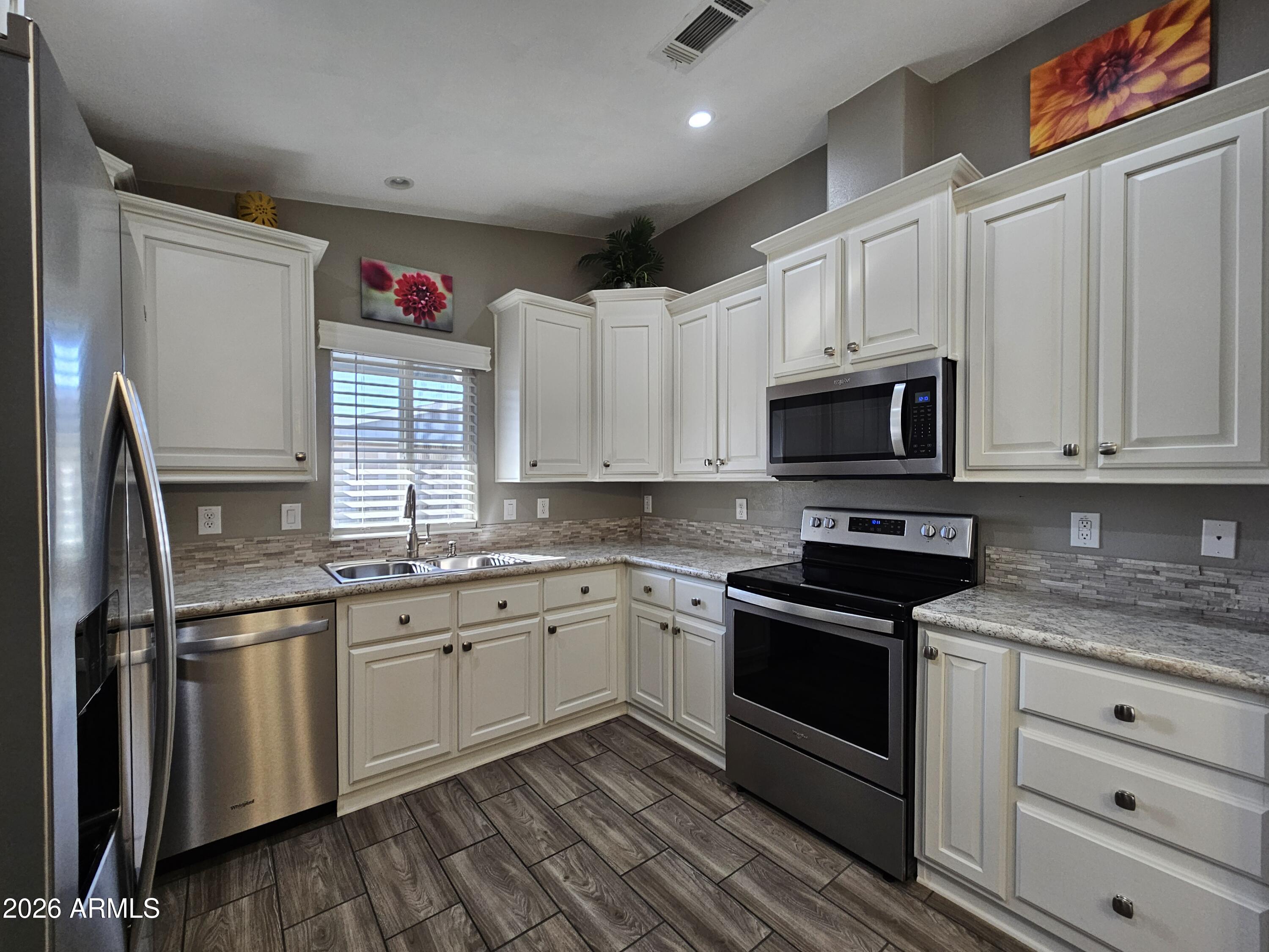 650 North Hawes Road, Unit 3516 Mesa, AZ 85207 - Photo 19 of 37 a kitchen with white cabinets stainless steel appliances and sink