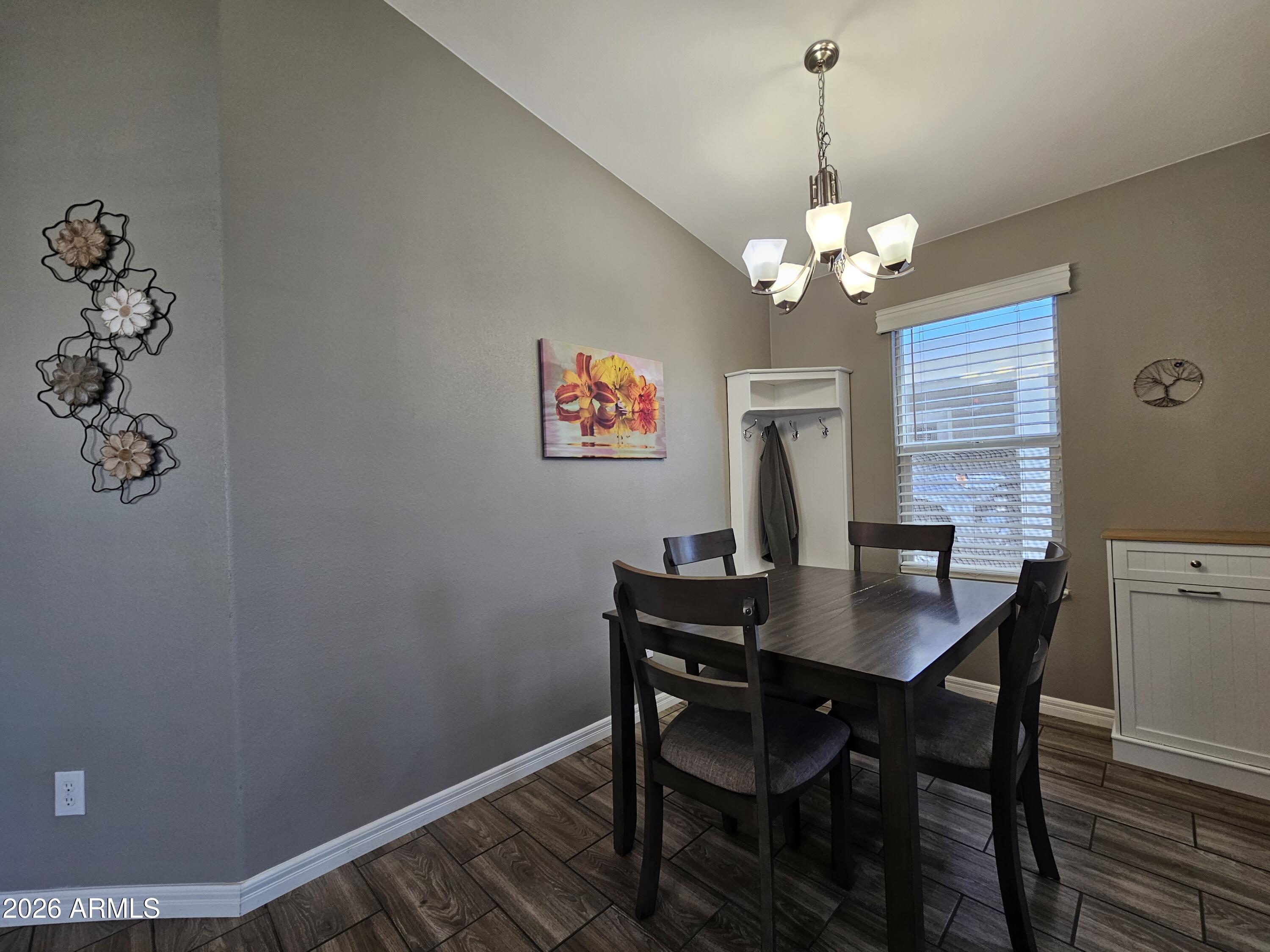 650 North Hawes Road, Unit 3516 Mesa, AZ 85207 - Photo 4 of 37 a view of a dining room with furniture wooden floor and a chandelier