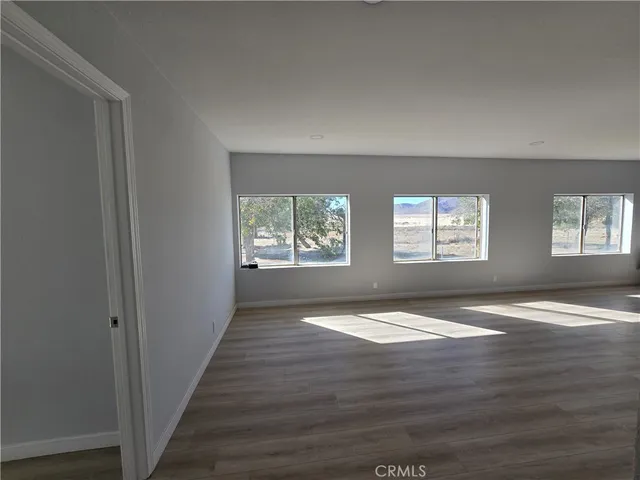 a view of an empty room and wooden floor