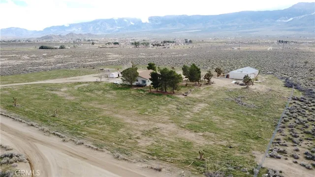 a view of a dry yard with mountains in the background