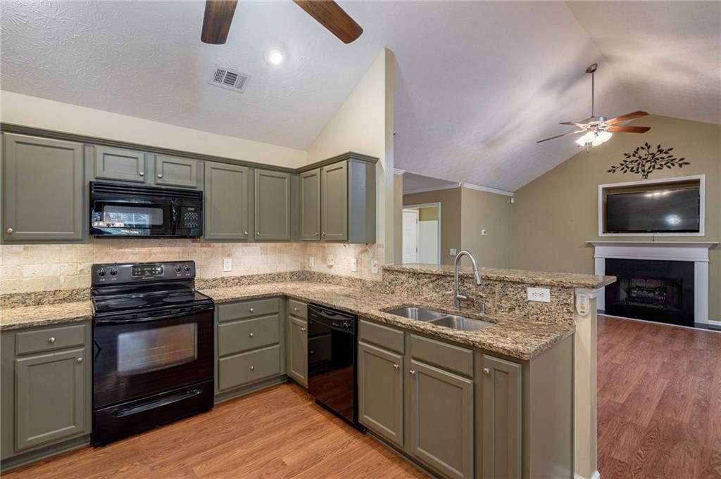 245 Memory Lane Winder, GA 30680 - Photo 17 of 62 a kitchen with granite countertop a stove and a sink