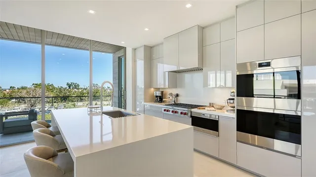 a kitchen with a sink a stove and chairs