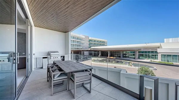 a view of a balcony with dining table and chairs