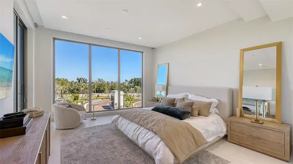 a bedroom with a large bed and a chandelier