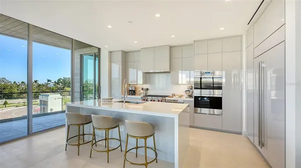 a kitchen with stainless steel appliances granite countertop a stove a sink a microwave a dining table and chairs